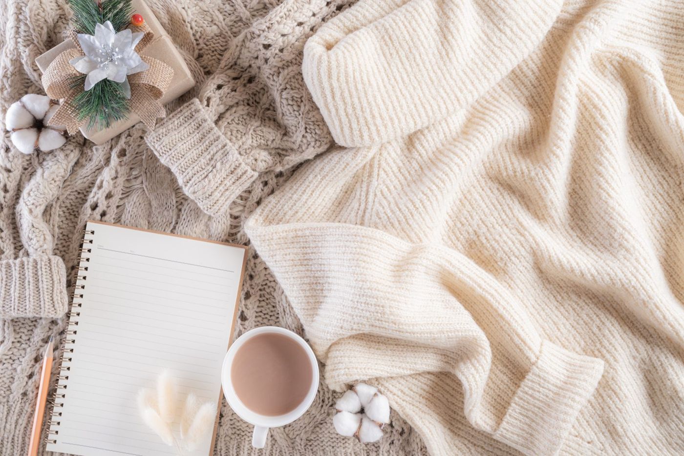 A soft knitted blanket, a warm drink and a notebook