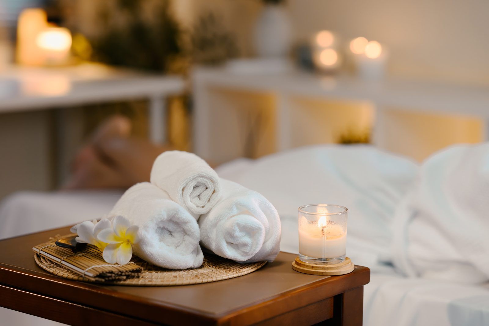 Rolled towels and candlelight in a calm treatment room